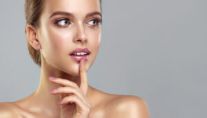 A woman touching her lips after getting hyaluronic acid fillers in KY